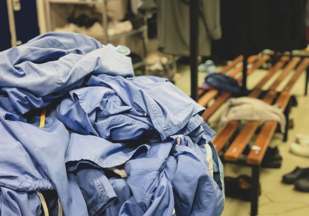 A clothes basket overflowing with surgical scrubs in the changing room of a hospital in the United Kingdom. This is seen often at the end of the day or on Sunday night.